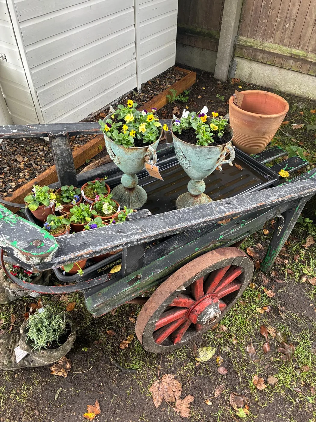 Close view of a vintage cart, planters and garden ornaments