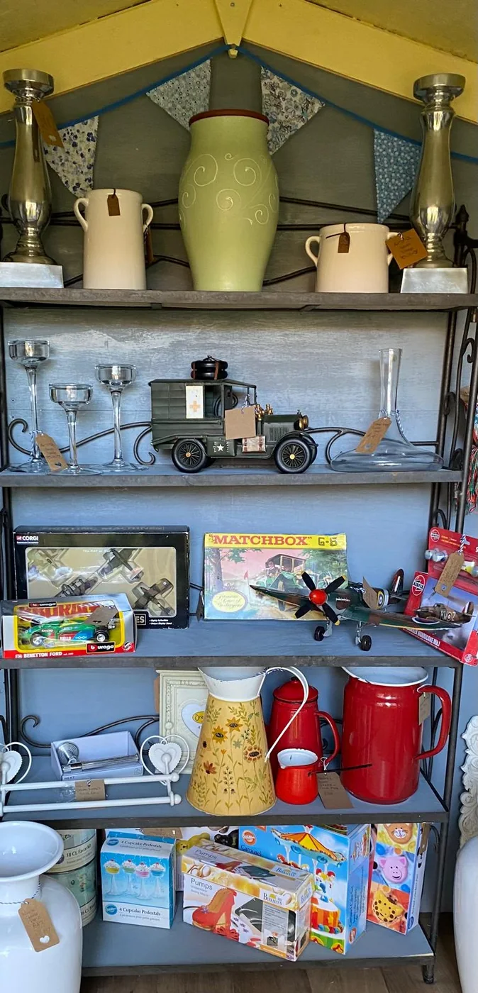 Shelves of vintage collectables, ceramics and model vehicles